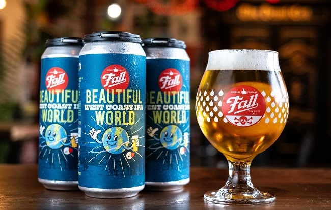 A tulip glass of golden ale alongside cans of Beautiful World IPA at Fall Brewing Company in San Diego.