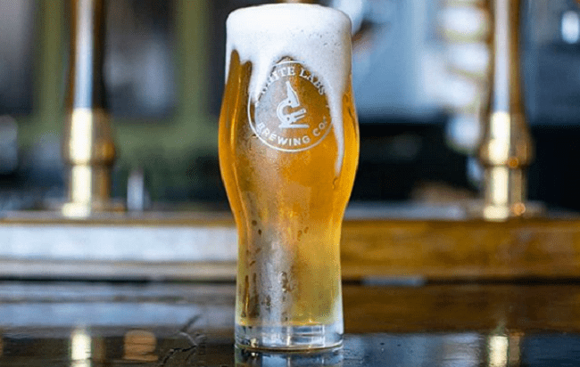 A frosty, branded glass of pour-over craft beer at White Labs Brewing Company in San Diego