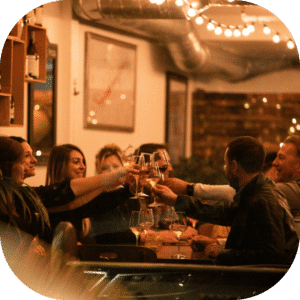 Group cheering glasses around table