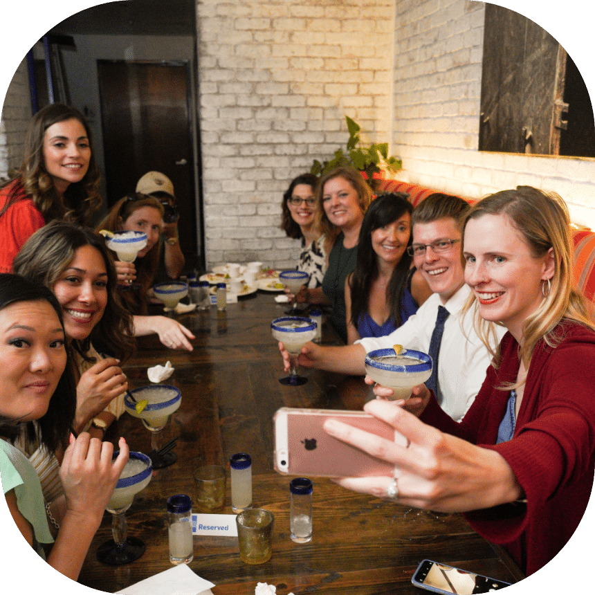 Group of friends taking photo at table on the Brothels Bites and Booze Gaslamp