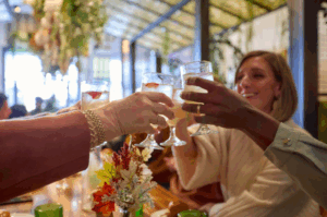 group of people holding up drink glasses to cheer