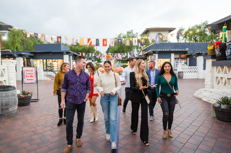 tour group walking through courtyard under handing lights and flags
